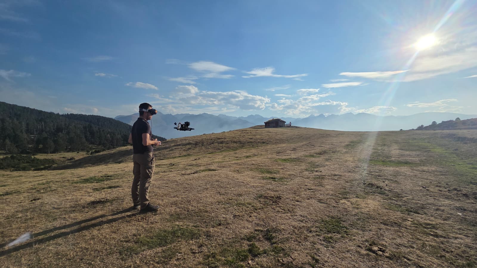 Clément pilote un drone avec son casque FPV dans un paysage de montagne